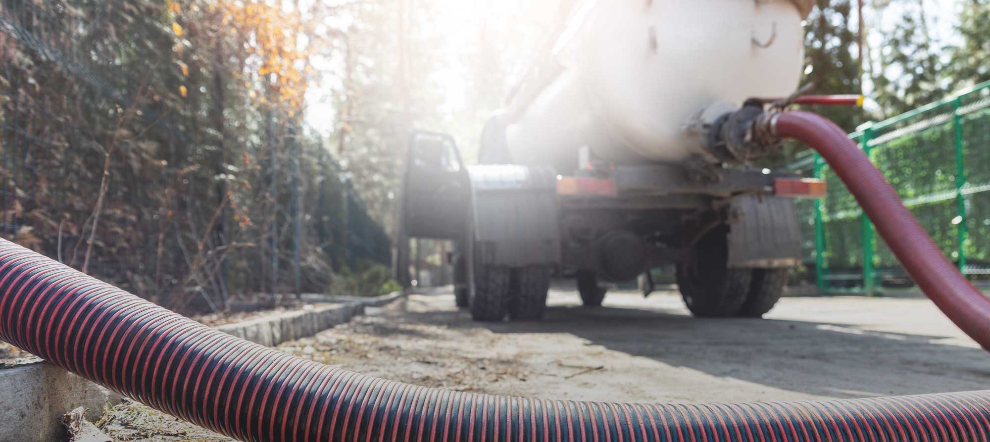 Image of septic pumping truck pumping a septic tank in a rural area
